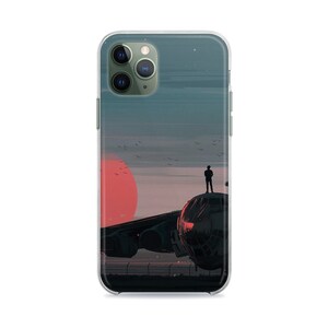 May include: A clear phone case with a graphic of a plane in front of a red sun and a silhouette of a person standing on the plane. The plane is on a runway with a fence in the background.