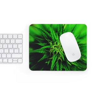 Könnte beinhalten: Grünes Mauspad mit einem Nahaufnahmebild einer Cannabispflanze. Eine weiße kabellose Maus befindet sich auf der rechten Seite des Mauspads. Eine weiße Tastatur ist in der oberen linken Ecke sichtbar.