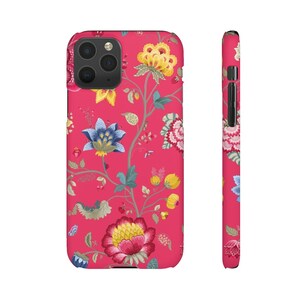 May include: A pink iPhone case with a floral pattern. The flowers are in shades of blue, yellow, and pink. The case has a black camera cutout.