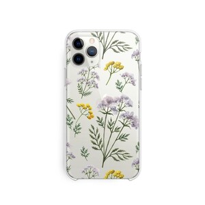 Peut inclure: Une coque de téléphone transparente avec un motif floral. Les fleurs sont jaunes et violettes et sont disposées en motif répétitif. La coque est conçue pour un iPhone.