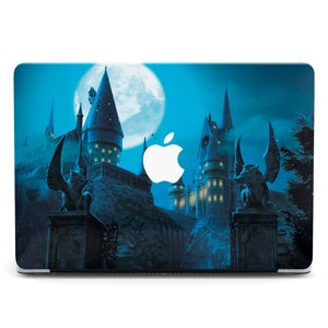 May include: A laptop skin featuring a dark blue night sky with a full moon and a silhouette of Hogwarts castle. The Apple logo is visible on the laptop screen.