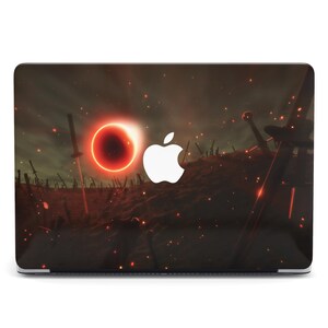 May include: A laptop cover featuring a dramatic scene with a fiery red sun and numerous swords embedded in the ground. The Apple logo is prominently displayed on the cover, which has a dark, atmospheric background.