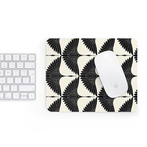 May include: Black and white mouse pad with a repeating pattern of stylized cranes with outstretched wings. A white wireless mouse is on the mouse pad.
