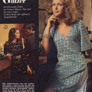 Puede incluir: Un vestido azul con estampado de estrellas y escote en V. El vestido tiene mangas cortas y una silueta ajustada. La modelo lleva un collar y una pulsera plateados. El texto "Glanz & Glitzer" es visible en la esquina superior izquierda de la imagen.