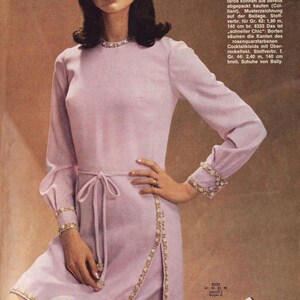 Puede incluir: Un vestido rosa claro con ribetes dorados y un lazo en la cintura. El vestido tiene una silueta de princesa y est&aacute; hecho de una tela suave y fluida. La modelo lleva el vestido con un par de sandalias doradas.