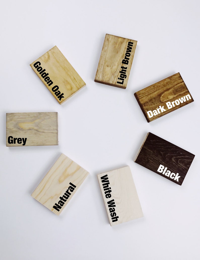 May include: A collection of small, rectangular wooden blocks, each stained a different color. Colors include Golden Oak, Light Brown, Dark Brown, Black, White Wash, Natural, and Grey. The color names are printed in black on each block.