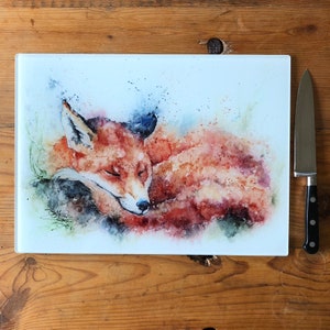 Puede incluir: Una pintura de acuarela de un zorro rojo durmiendo sobre un fondo blanco. El zorro está acurrucado con la cabeza apoyada en sus patas. La pintura está hecha en un estilo realista con colores suaves y apagados.