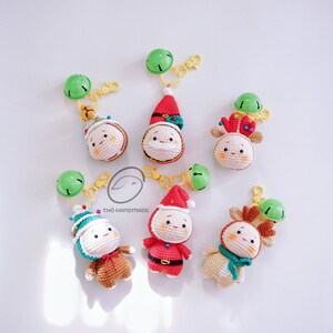 May include: Six crocheted Christmas ornaments with keychains. The ornaments are a Santa Claus, a reindeer, a snowman, and a Christmas tree. The ornaments are all white with red, green, and brown accents. The keychains are silver and have a small bell on the end.