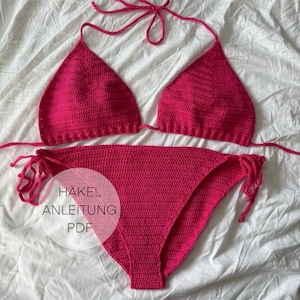 Könnte beinhalten: Ein pinkfarbener Häkel-Bikini-Oberteil und -Unterteil auf weißem Hintergrund. Der Text "HÄKEL ANLEITUNG PDF" befindet sich in der Mitte des Bildes.