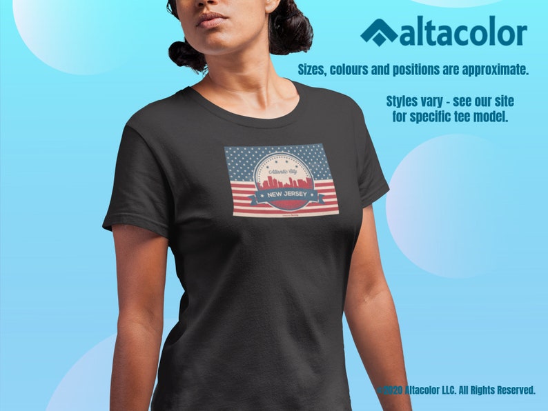 Może przedstawiać: Czarny T-shirt z grafiką w stylu vintage przedstawiającą panoramę Nowego Jorku. Grafika zawiera projekt amerykańskiej flagi w kolorze czerwonym, białym i niebieskim z tekstem "Garden State" i "NEW JERSEY".