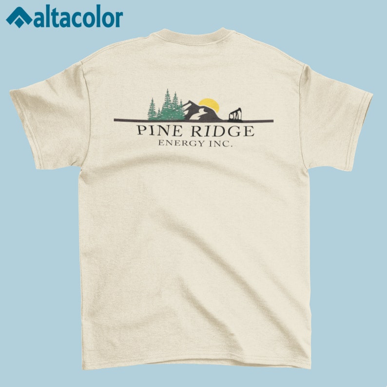 May include: A beige t-shirt with a graphic of a mountain range, trees, and a sun. The text "PINE RIDGE ENERGY INC." is printed below the graphic.