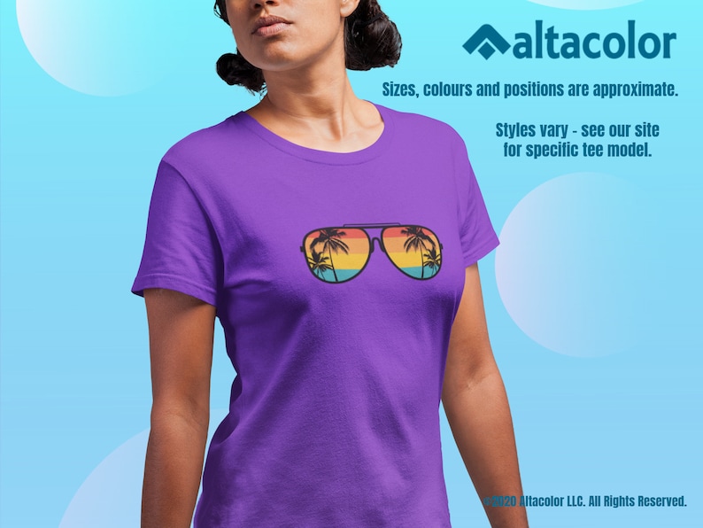 Może przedstawiać: Fioletowy T-shirt z grafiką okular&oacute;w przeciwsłonecznych odbijających palmy i zach&oacute;d słońca. Tekst "Styles vary - see our site for specific tee model." jest nadrukowany pod grafiką.