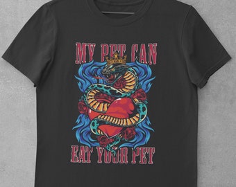 Może przedstawiać: Czarny t-shirt z kolorową grafiką przedstawiającą ukoronowanego węża owiniętego wokół czerwonego serca. Tekst "MY PET CAN EAT YOUR PET" jest wyświetlany nad i pod grafiką w stylu vintage.