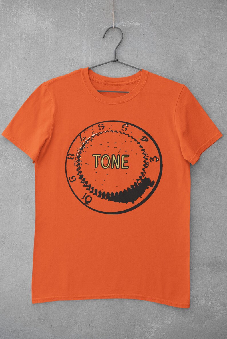 Puede incluir: Camiseta naranja con un gr&aacute;fico en blanco y negro de una perilla de guitarra con la palabra "TONE" impresa en amarillo.