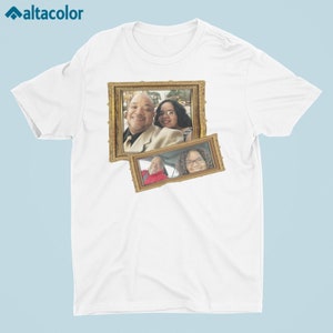 Puede incluir: Camiseta blanca con una foto enmarcada en dorado de una familia. La foto muestra un hombre y dos mujeres.