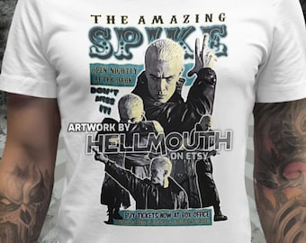 Puede incluir: Una camiseta blanca con un estampado gráfico de un personaje de la serie de televisión Buffy la cazavampiros. El gráfico presenta al personaje Spike con el texto "The Amazing Spike" y "Open Nightly After Dark" y "Don't Miss It". El gráfico también incluye el texto "Artwork by Hellmouth on Etsy".