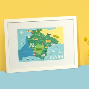 May include: A colorful illustrated map of Devon, England, with the words "DEVON" printed in large letters at the bottom. The map features various landmarks, towns, and cities, including Exeter, Plymouth, and Dartmoor. The map is framed in a white frame.