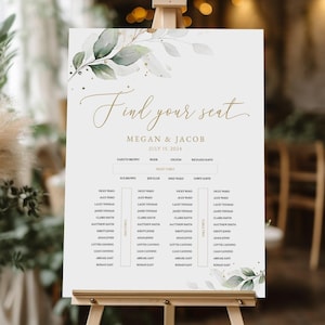 Può includere: Un tableau de mariage bianco con lettere dorate e un'illustrazione ad acquerello di foglie verdi e glitter dorati. Il tableau è intitolato "Find your seat" con i nomi "Megan & Jacob" e la data "July 12, 2024".