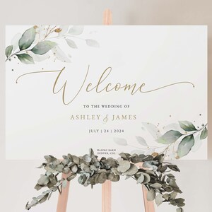 K&ouml;nnte beinhalten: Willkommensschild mit gr&uuml;nem und goldenem Laub, der Text lautet "Welcome to the wedding of Ashley & James July 24 2024 Wasing Barn Denver, Col"