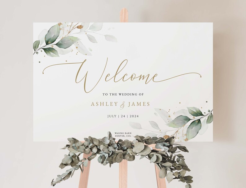 K&ouml;nnte beinhalten: Willkommensschild mit gr&uuml;nem und goldenem Laub, der Text lautet "Welcome to the wedding of Ashley & James July 24 2024 Wasing Barn Denver, Col"