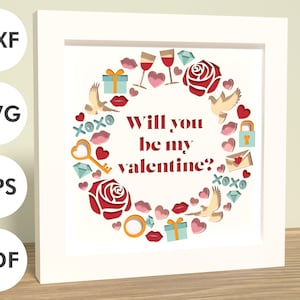 May include: White frame with a white mat and a red, white, and blue paper cut design. The design is a circle with the text "Will you be my valentine?" in the center. The circle is surrounded by hearts, doves, keys, and other Valentine's Day themed imagery.