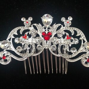 K&ouml;nnte beinhalten: Silberner Haarkamm mit einem dekorativen Design mit roten Mickey-Maus-K&ouml;pfen und klaren Strasssteinen.