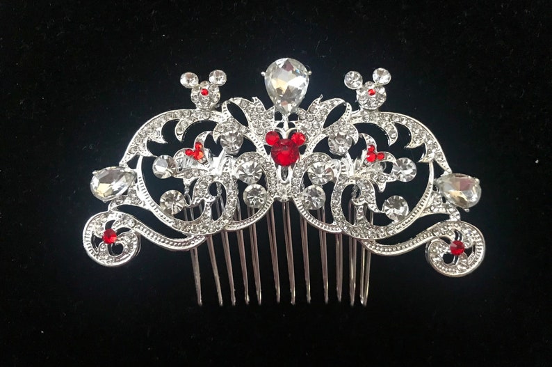 K&ouml;nnte beinhalten: Silberner Haarkamm mit einem dekorativen Design mit roten Mickey-Maus-K&ouml;pfen und klaren Strasssteinen.