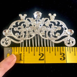 K&ouml;nnte beinhalten: Silberner Haarkamm mit Strassstein-Design und zwei Mickey-Maus-Ohren. Der Kamm ist etwa 7,6 cm lang.