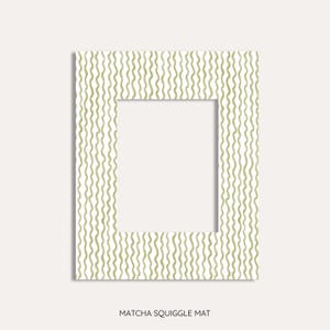 May include: A rectangular photo mat with a white center and a matcha green squiggly pattern border. The text "Matcha Squiggle Mat" is at the bottom. The mat is designed for displaying photos or artwork.