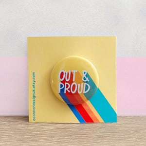 LGBTQ+ Pin Badge - Out and Proud - Coming Out Button Badge - Pride Month Rainbow - Lesbian, Gay, Bisexual, Trans, Queer Gift - 30mm Badge