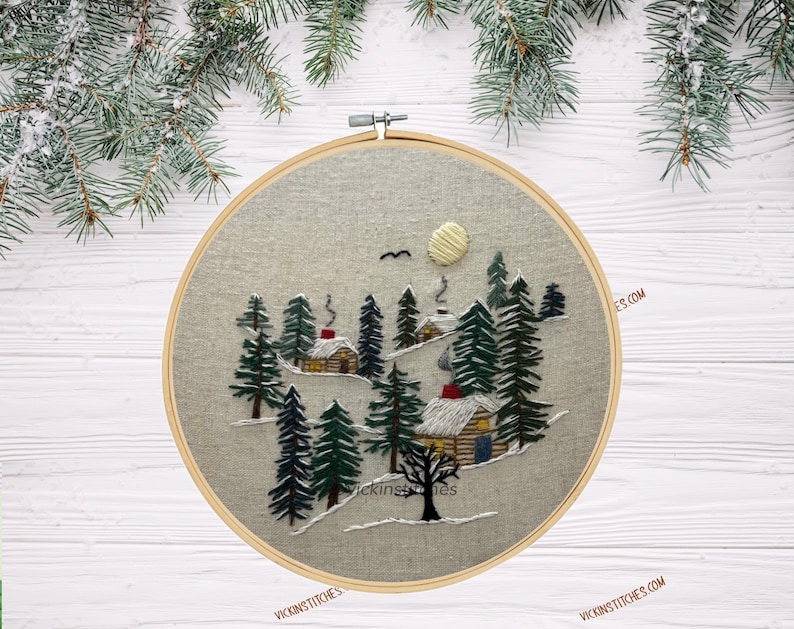 Embroidery kit featuring 3 cabins nestled in a-snowy pine woods