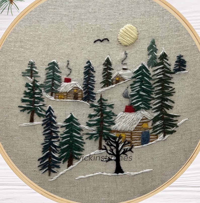Embroidery kit featuring 3 cabins nestled in a-snowy pine woods