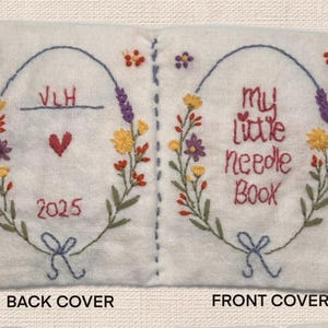 May include: A white, embroidered needle book with floral wreath designs. The front cover reads "my little needle book" in red script. The back cover has the initials "VLH", a heart, and the year "2025".