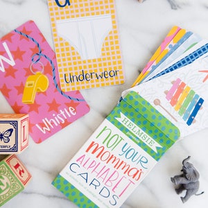 May include: A box of alphabet flash cards with a green, blue, and white polka dot pattern. The box says "Not Your Momma's Alphabet Cards" and "an eclectic mix of nostalgic and modern".