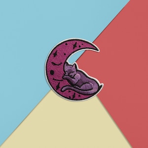 May include: Purple embroidered patch of a cat sleeping on a crescent moon with a white outline.