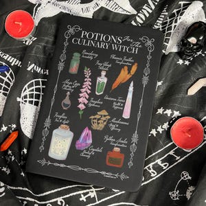 Könnte beinhalten: Schwarzes Notizbuch mit dem Text "POTIONS For The CULINARY WITCH" und Illustrationen von Zutaten für Tränke. Das Notizbuch ist von Kerzen und einem dekorativen Totenkopf umgeben.