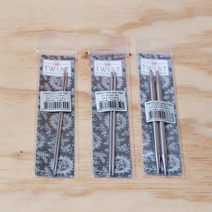 May include: Three packages of Twist SS Lace Tip knitting needles. The packages are labeled with the size, 5" (13 cm) and US size 1 (2.25 mm), US size 2 (2.75 mm), and US size 3 (3.25 mm).