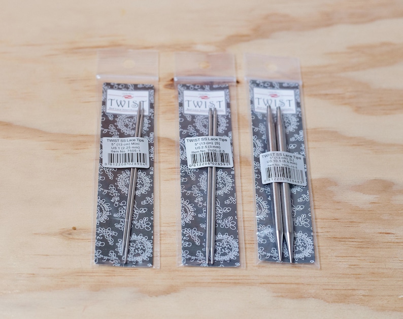 May include: Three packages of Twist SS Lace Tip knitting needles. The packages are labeled with the size, 5" (13 cm) and US size 1 (2.25 mm), US size 2 (2.75 mm), and US size 3 (3.25 mm).