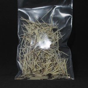 May include: A clear plastic bag filled with a large quantity of thin, light brown and white feathers. The feathers are arranged in a random, chaotic pattern.