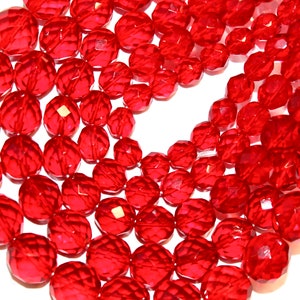 May include: A close-up of a strand of red faceted glass beads. The beads are round and have a shiny finish.