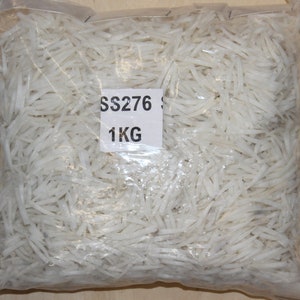 May include: A clear plastic bag filled with white, thin, and long pieces of material. The bag has a label that says "SS276 1KG".