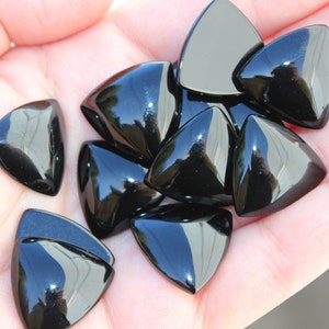 Peut inclure: Dix pierres précieuses cabochon triangulaires noires. Les pierres sont lisses et polies, avec une finition brillante.