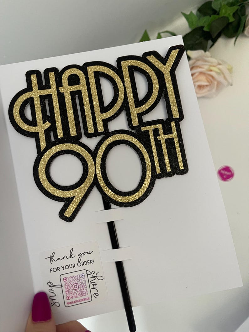 May include: Gold and black glitter cake topper that says "Happy 90th".