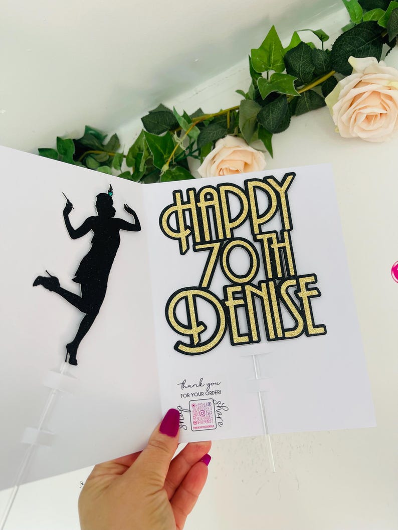 May include: Gold glitter cake topper with the text "Happy 70th Denise". The topper features a black silhouette of a woman in a flapper dress.
