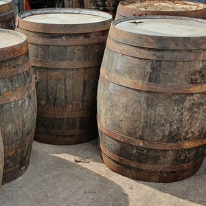 May include: Four wooden barrels with metal hoops. The barrels are brown and have a rustic appearance.