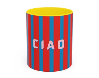 Op de afbeelding: Een rood-blauw gestreepte keramische mok met een gele rand. De mok heeft het woord "CIAO" in roze letters.