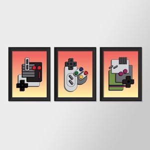 May include: Three framed prints with a retro gaming theme. Each print features a different design of a video game controller, with a red, white, and blue colour scheme.