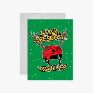 May include: A green Christmas card with a red hockey helmet with antlers and the text "Stack Presents Not Bikes".