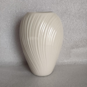 May include: A set of three ceramic mugs with a speckled, matte finish. The mugs are in shades of cream, light gray, and dark gray. Each mug has a simple, minimalist design, perfect for coffee or tea.