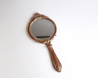 Antico specchio a mano in bronzo dorato.